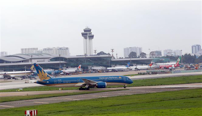 Hoạt động đi lại của người dân bằng đường hàng không đang tăng nhanh trong những ngày gần đây. (Ảnh: Hành khách làm thủ tục tại sân bay Tân Sơn Nhất hôm 19/1).