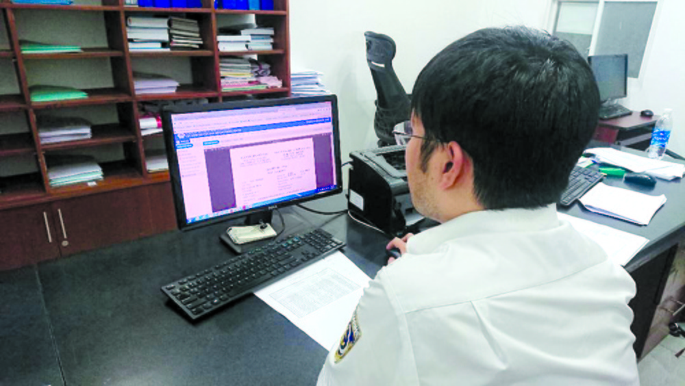 Cán bộ Cảng vụ Hàng hải TP Hồ Chí Minh kiểm tra hồ sơ khai báo điện tử để làm thủ tục cấp giấy phép cho tàu ra - vào cảng.