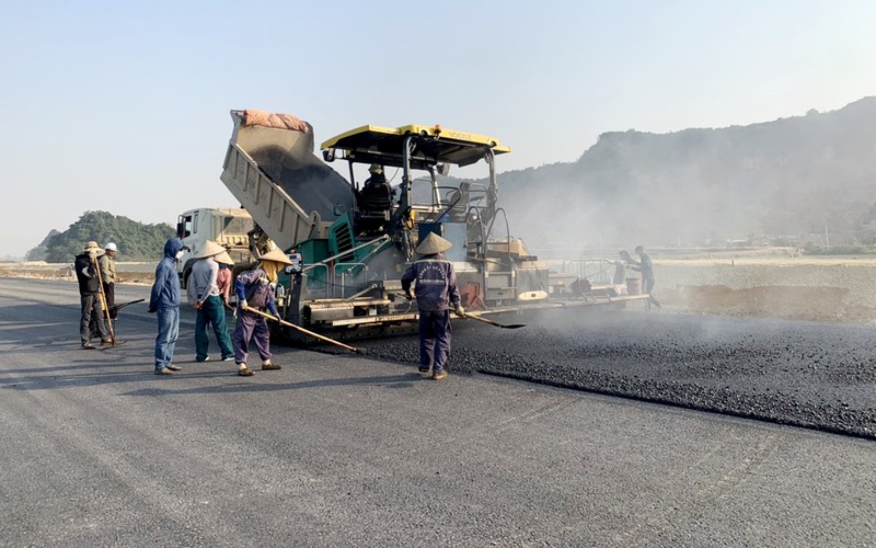 Các công nhân tranh thủ thời tiết nắng ráo thi công giữa trưa để thảm bê tông nhựa tại Dự án thành phần Mai Sơn - Quốc lộ 45 (Ảnh chụp vào tháng 2/2023).