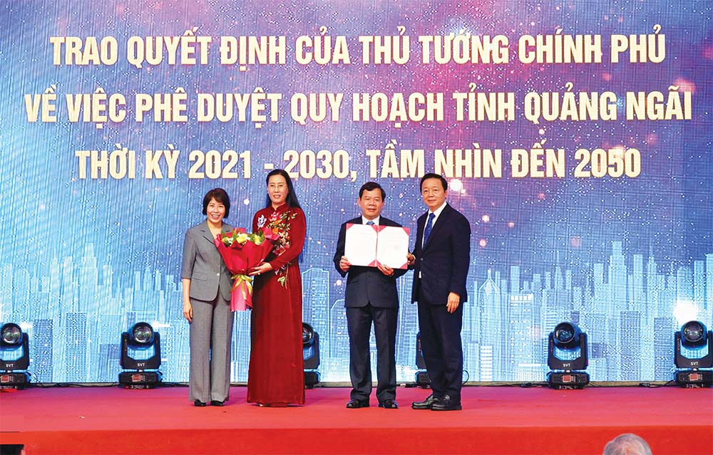 Phó thủ tướng Trần Hồng Hà (bìa phải) và Thứ trưởng Bộ Kế hoạch và Đầu tư Nguyễn Thị Bích Ngọc (bìa trái) trao Quyết định phê duyệt Quy hoạch tỉnh Quảng Ngãi thời kỳ 2021 - 2030, tầm nhìn đến năm 2050 và tặng hoa cho lãnh đạo tỉnh Quảng Ngãi