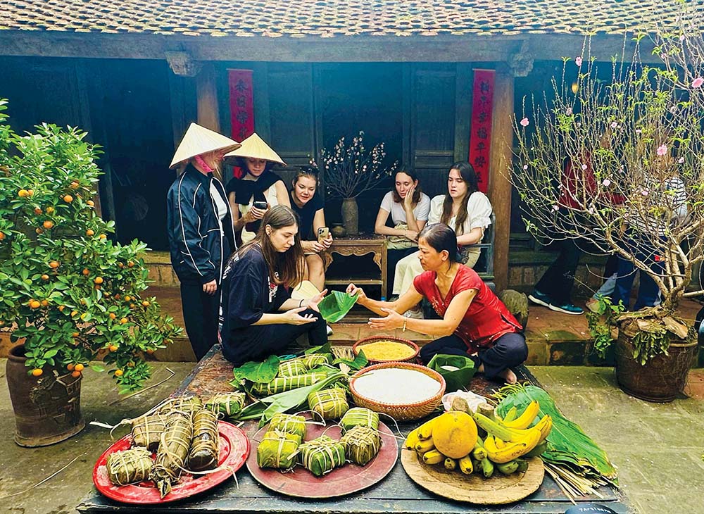 Sinh viên quốc tế trải nghiệm gói bánh chưng trong tour du lịch tại làng cổ Đường Lâm (Hà Nội)	Anh: Linh Tâm
