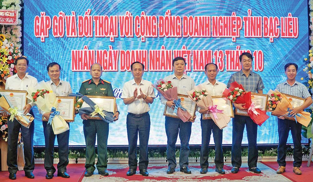 Ông Phạm Văn Thiều, Chủ tịch UBND tỉnh Bạc Liêu (đứng thứ tư từ trái qua) trao bằng khen cho doanh nghiệp, nhà đầu tư tiêu biểu của tỉnh 
