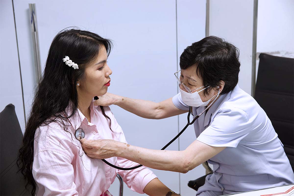 Bác sĩ đo tim phổi của khách hàng trước khi thực hiện tiêm chủng