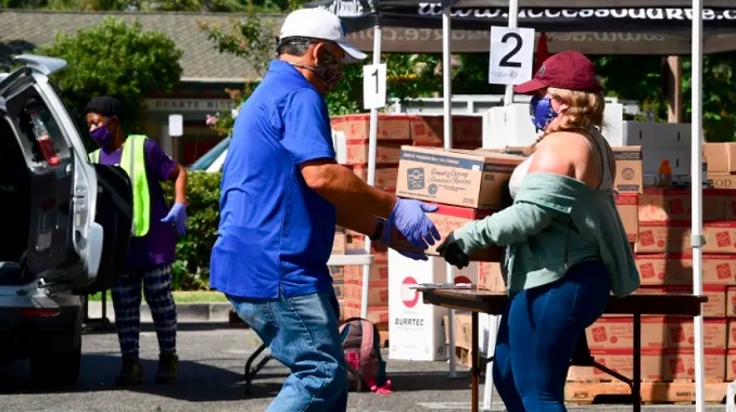 Các tình nguyện viên của một ngân hàng thực phẩm ở thành phố Duarte, bang California, khuôn xếp các thùng đồ ăn quyên góp. Ảnh: AFP