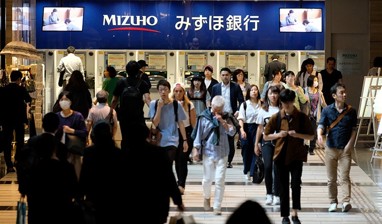 Người qua đường di chuyển trong khu vực mua sắm ở Tokyo. Ảnh: AFP