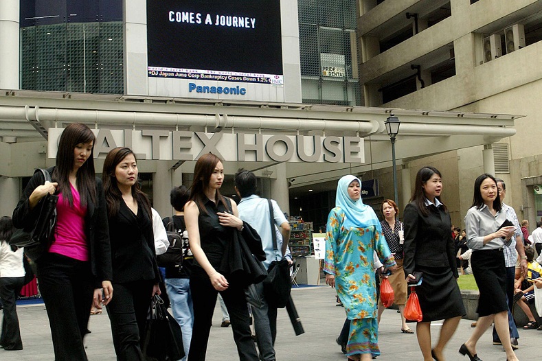 Các nhân viên văn phòng đi bộ tại khu tài chính Raffles Place ở Singapore. Ảnh: AFP