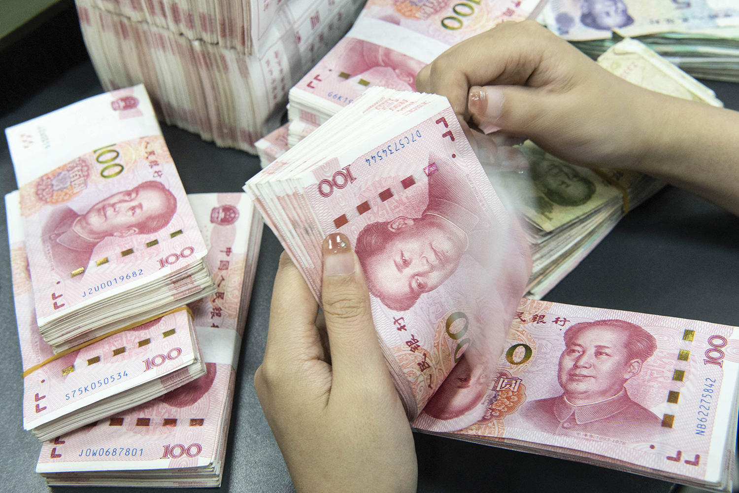Nhân viên ngân hàng đếm các tờ tiền mệnh giá 100 nhân dân tệ ở Nam Thông, phía đông tỉnh Giang Tô, Trung Quốc. Ảnh: AFP
