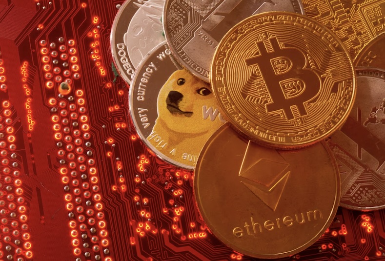 Các hình ảnh đại diện của tiền điện tử Bitcoin, Ethereum, DogeCoin, Ripple, Litecoin được đặt trên bo mạch chủ PC. Ảnh: Reuters