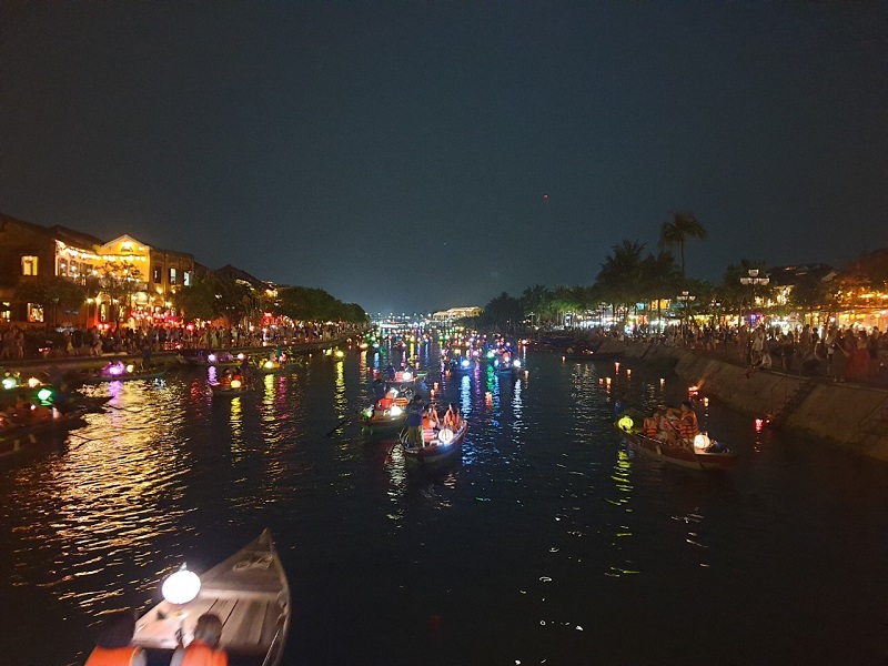 Du khách thưởng ngoạn, thả hoa đăng trên sông Hoài, thành phố Hội An về đêm. 