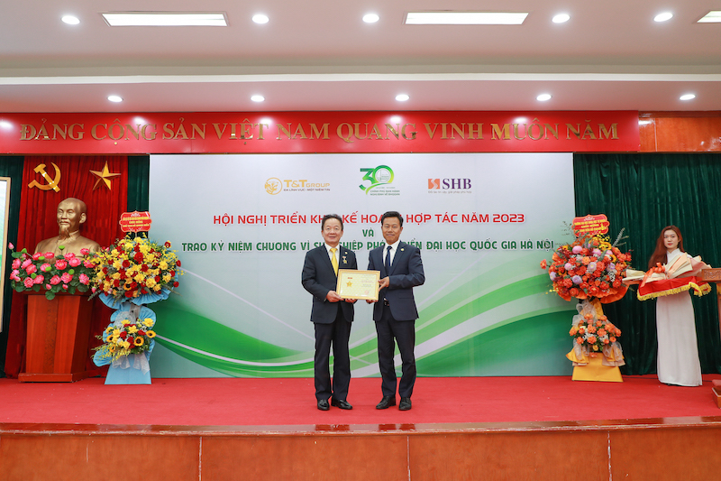 GS.TS Lê Quân (bên phải) trao kỷ niệm chương vì sự nghiệp phát triển ĐHQGHN cho doanh  nhân Đỗ Quang Hiển.