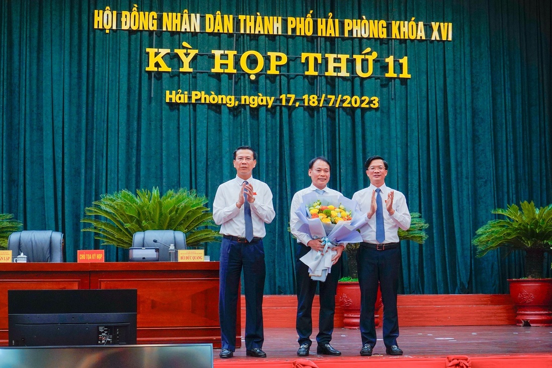 Ông Phạm Văn Lập, Chủ tịch HĐND Thành phố và ông Bùi Đức Quang, Phó Chủ tịch HĐND Thành phố tặng hoa chúc mừng ông Lê Minh Quang, Giám đốc Sở y tế được bầu vào chức danh Ủy viên UBND Thành phố