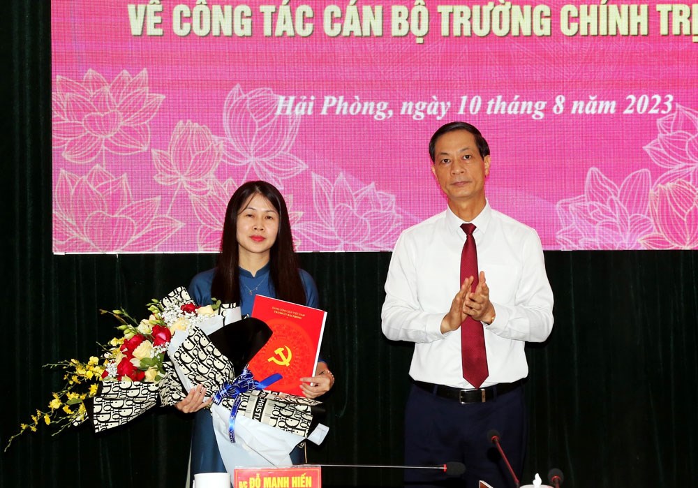 Ông Đỗ Mạnh Hiến, Phó Bí thư Thường trực Thành ủy Hải Phòng trao Quyết định và tặng hoa cho bà Trần Thị Thanh Minh, Phó Hiệu trưởng Trường Chính trị Tô Hiệu
