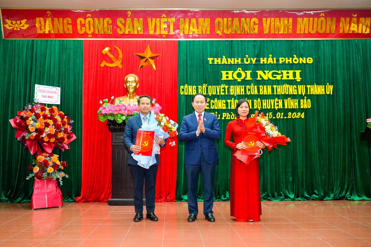 Ông Lê Tiến Châu, Bí thư Thành ủy Hải Phòng trao Quyết định và tặng hoa chúc mừng ông Nguyễn Hoàng Long và bà Phạm Tuyên Dương nhận nhiệm vụ mới