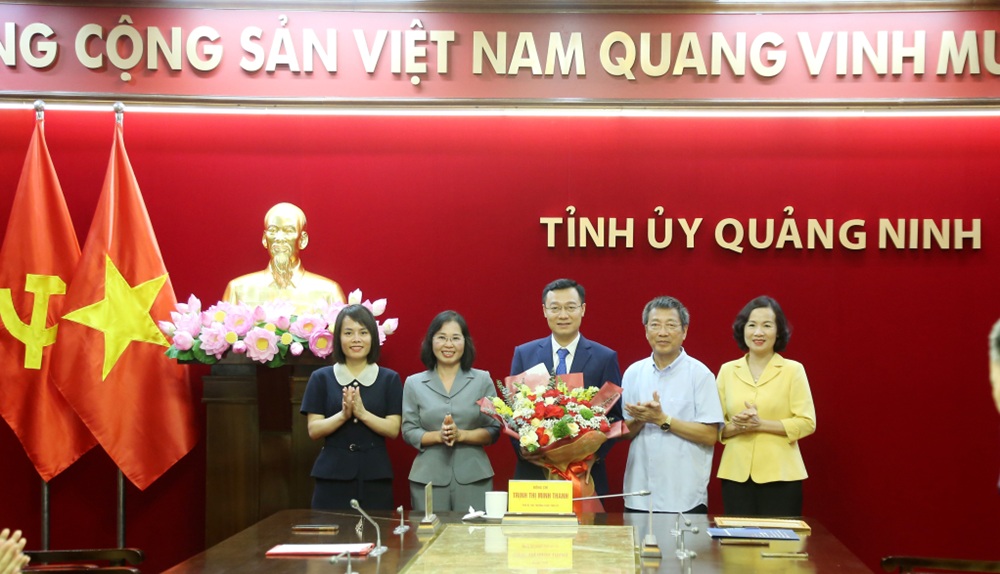 Lãnh đạo tỉnh Quảng Ninh tặng hoa chúc mừng tân Giám đốc, Tổng biên tập Trung tâm Truyền thông tỉnh. Ảnh: Thu Chung