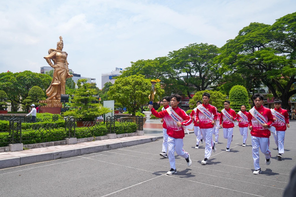 Đoàn vận động viên thực hiện nghi lễ rước lửa qua Tượng đài Nữ tướng Lê Chân