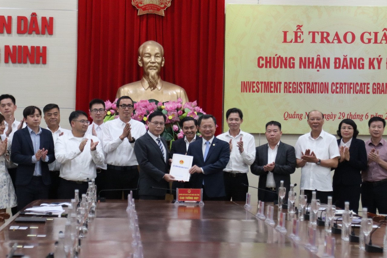 Ông Cao Tường Huy, Quyền Chủ tịch UBND tỉnh Quảng Ninh (bên phải màn hình) trao giấy chứng nhận đầu tư cho Tập đoàn Foxconn.