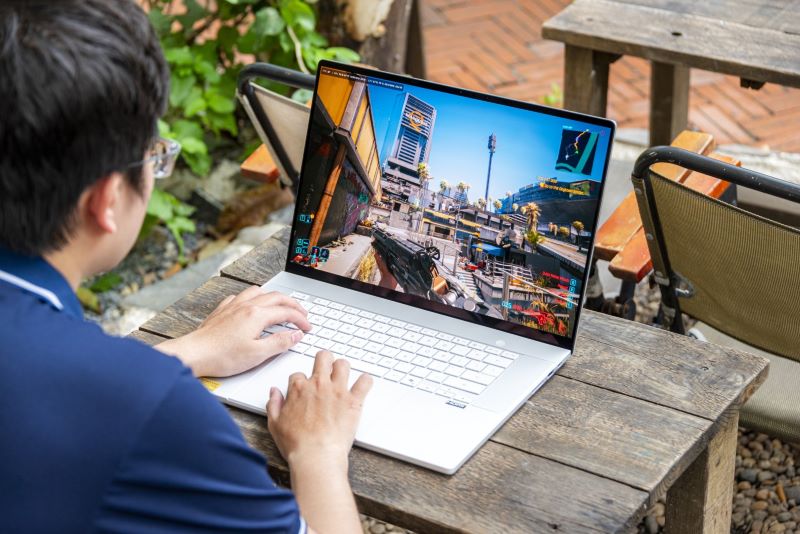 Người d&ugrave;ng trải nghiệm chơi game tr&ecirc;n laptop ngo&agrave;i trời. Ảnh: ASUS