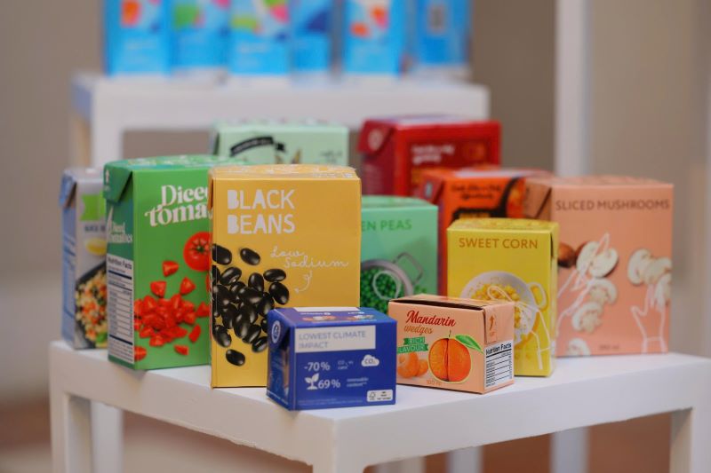 C&aacute;c loại thực phẩm đ&oacute;ng sẵn như đậu đen, c&agrave; chua, ng&ocirc; ngọt, nấm v&agrave; qu&yacute;t được đựng trong hộp giấy nhiều m&agrave;u thay cho lon kim loại truyền thống. Ảnh: Vinafosa