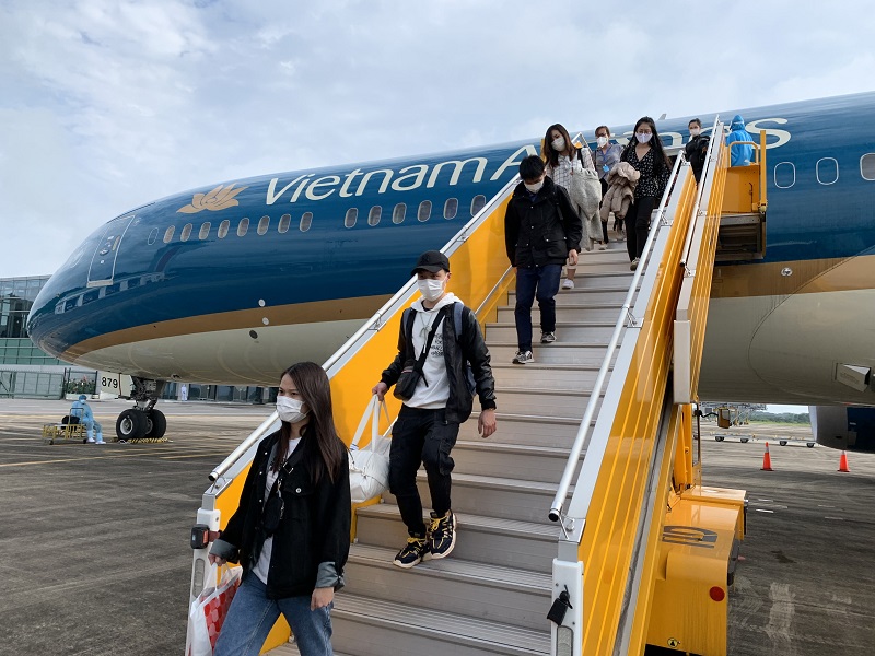 Các hành khách xuống sân bay Nội Bài sau chuyến bay từ Nhật Bản được vận chuyển bởi Vietnam Airlines,