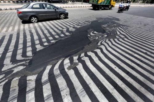 Nhựa đường ở New Delhi chảy vì nắng nóng. Ảnh: EPA