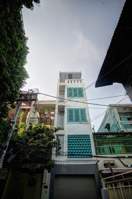 Đây là không gian sống của người chủ độc thân từng học tập và đi du lịch nhiều nước, ở cùng với một người cô đã đứng tuổi. Ngôi nhà trong hẻm nhỏ Sài Gòn nổi bật nhờ những ô thông gió cùng cửa lá sách sơn xanh.