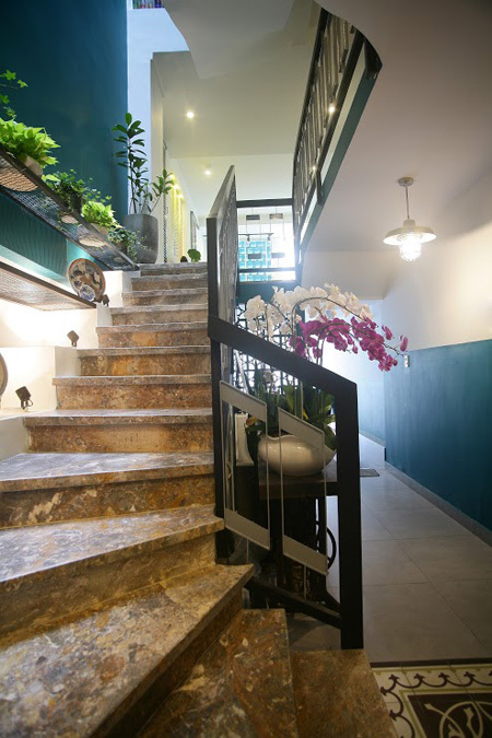 Cầu thang nằm ở giữa nhà, nối liền với khoảng thông tầng và một góc vườn xanh nho nhỏ.