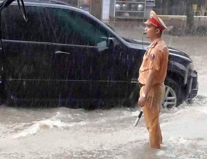 Đội mưa và lội nước để đảm bảo giao thông trên các ngả đường.