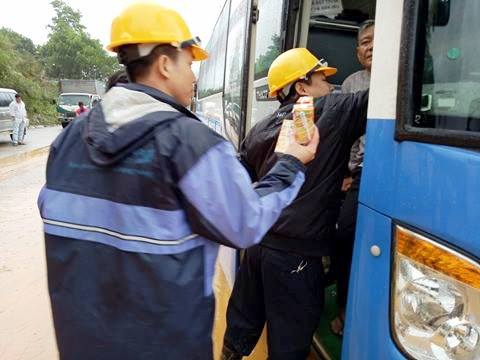 Cán bộ công ty Thủy điện Đăk Mi hỗ trợ nước uống và bánh cho hành khách mắc kẹt tại khu vực sạt lở tại thị trấn Khâm Đức- Quảng Nam.