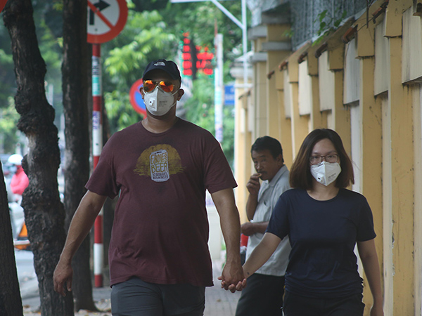 người nước ngoài đi bộ trên vỉa hè đường Ngô Thời Nhiệm Q3, cũng phải trang bị khẩu trang và mắt kính