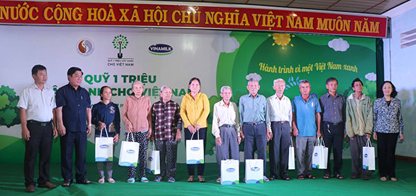 Bà Trương Thị Mai - Ủy viên Bộ Chính trị, Bí thư Trung ương Đảng, Trưởng ban Dân vận Trung ương cùng các đại biểu trao tặng 10 phần quà của Ban Tổ chức cho các gia đình thuộc diện chính sách của tỉnh Bình Định