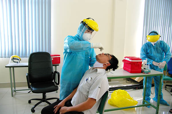 Nhân viên HCDC đang lấy mẫu nhân viên Công ty Organ Needle Việt Nam tại Khu chế xuất (KCX) Tân Thuận