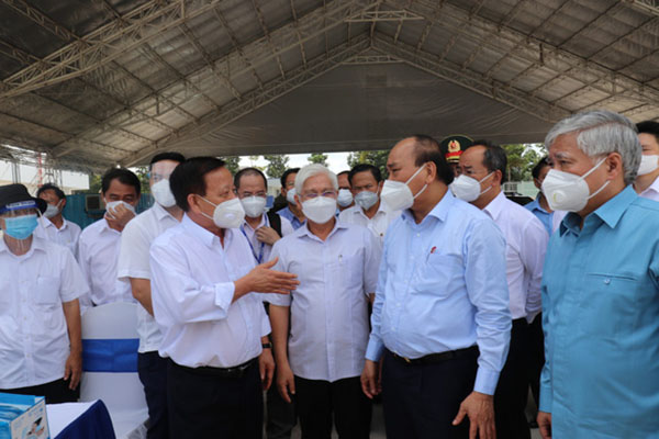 Chủ tịch nước Nguyễn Xuân Phúc (thứ hai từ phải qua) kiểm tra tại công trường xây dựng khu điều trị dã chiến số 2 với quy mô 40.000m2 tại KCN Mỹ Phước 4, tỉnh Bình Dương.