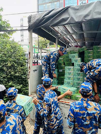 Các chiến sĩ Trung tâm Huấn luyện Vùng 4 Hải quân đang chuyền nhau các sản phẩm dinh dưỡng Vinamilk, sẵn sàng vận chuyển đến tận tay bà con vùng lũ - Ảnh: Vi Nam