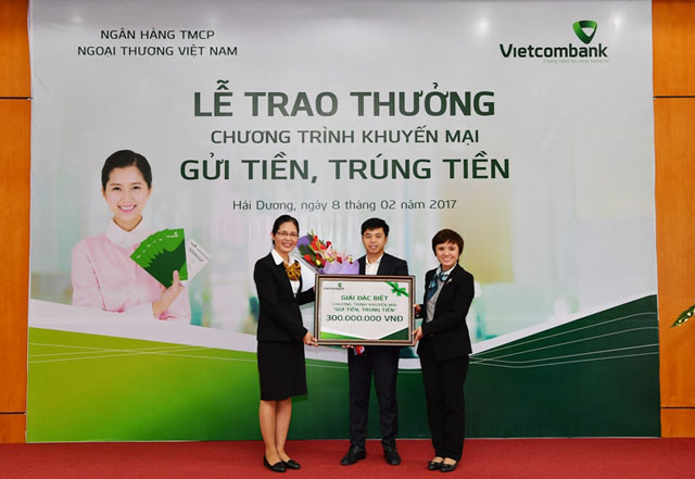 Bà Thái Thu Hằng – Phó Trưởng phòng Quản lý bán sản phẩm bán lẻ TSC (bên phải) và bà Nguyễn Thị Thêu – Giám đốc Vietcombank Hải Dương (bên trái) trao giải Đặc biệt và tặng hoa cho khách hàng Dư Tuấn Dũng 