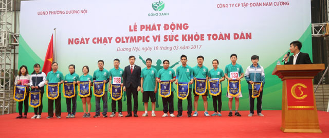 Ông Trần Oanh, Phó chủ tịch  Tập đoàn Nam Cường trao cờ lưu niệm cho các đơn vị tham gia Giải chạy