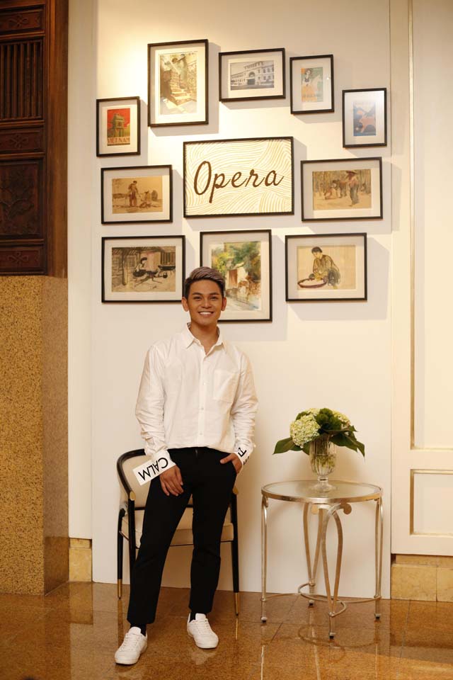 Là một trong những vị khách đến sớm nhất, Sơn Ngọc Minh háo hức tạo dáng bên những bức tranh lấy cảm hứng từ Sài Gòn xưa của nhà hàng, được sắp đặt một cách khéo léo và tinh tế trong không gian nội thất châu Âu