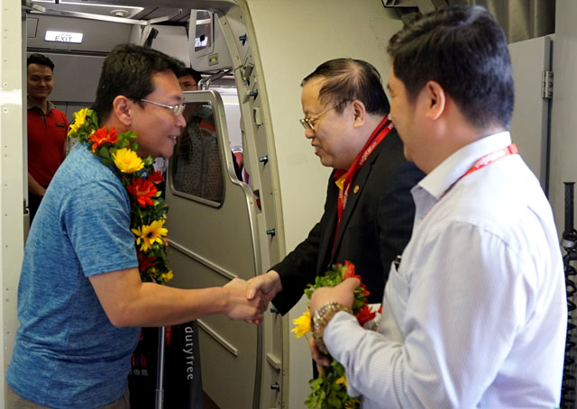 Lãnh đạo Vietjet chào đón và tặng hoa cho những hành khách đầu tiên trên chuyến bay khai trương