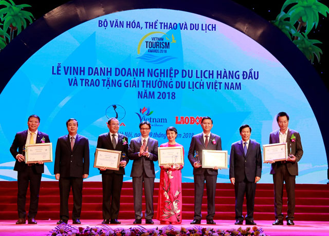 Bà Hoàng Thị Mỹ Hạnh – Phó Tổng Giám đốc Công ty Cổ phần Vinpearl (áo dài đỏ) nhận giải doanh nghiệp đầu tư và kinh doanh du lịch hàng đầu Việt Nam