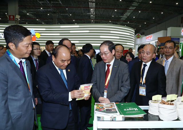 Thủ tướng Chính phủ Nguyễn Xuân Phúc lắng nghe Lãnh đạo Hapro giới thiệu về sản phẩm Gạo Hapro Đồng Tháp tại Hội chợ nhập khẩu Quốc tế Trung Quốc 2018 (tháng 11/2018)