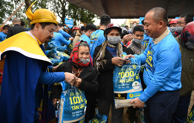 Ông Đoàn Văn Hiểu Em (bên phải) trao gạo cho người dân Lệ Thuỷ Quảng Bình trong lễ khởi động Tết sẻ chia 2021