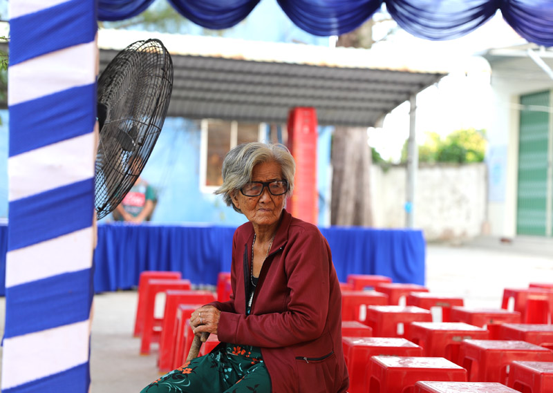 Ngay từ sáng sớm, bà Trần Thị Lã, 83 tuổi ở ấp Cảng Muối có mặt tại trụ sở UBND xã Hòa Đông chờ khám bệnh. Bà cho biết “Các con đều đi làm ăn xa, tui ở nhà có một mình. Giờ già rồi nên ngày càng ốm, hay đau đầu chóng mặt lắm, nhưng chúng nó gọi về hỏi thăm tui đâu dám kêu bệnh”