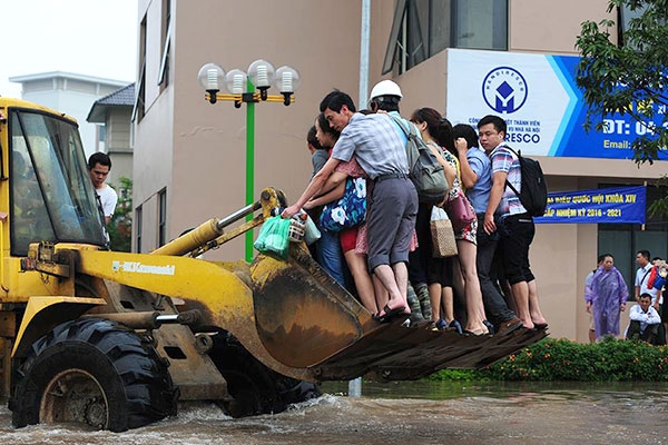 Máy ủi vận chuyển người qua chỗ ngập nước tại Khu đô thị Resco (Bắc Từ Liêm) - Ảnh: K.Linh
