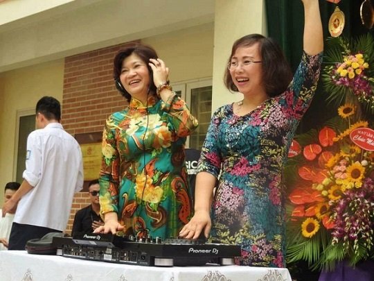 Cô Hiệu trưởng Phạm Thị Xuân Hương đeo tai nghe và đứng ở vị trí DJ điều khiển nhạc cho toàn trường
