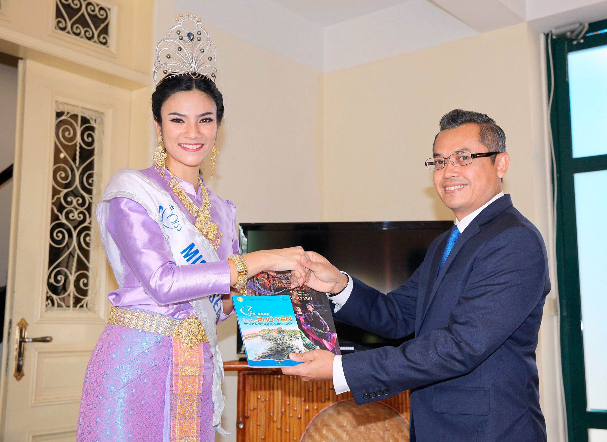 Hoa hậu Nuttanan Naree người Thái Lan tặng những ấn phẩm truyền thông chính thức cho Tham tán/ Phó đại sứ Malaysia Roslan Bin Sharif