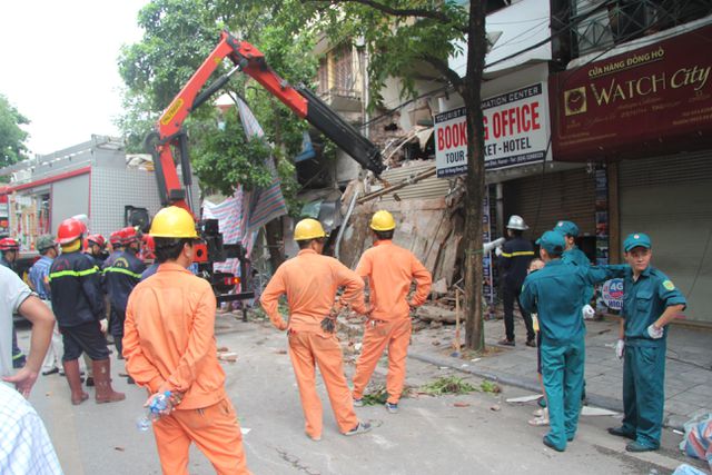 Sau trận mưa lớn lúc rạng sáng, người dân phát hiện bức tường ở tầng 2 bị đổ nghiêng ra bên ngoài nên vội vàng đặt các vật dụng ở gần đó để cảnh báo người đi đường.