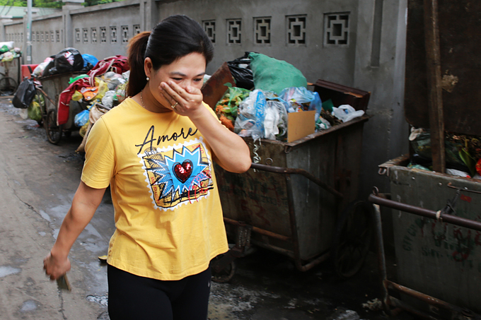 Trong ngõ nhỏ đầu đường Dương Quảng Hàm (Cầu Giấy), người dân bịt mũi bước qua dãy xe rác kéo dài hàng chục mét. 