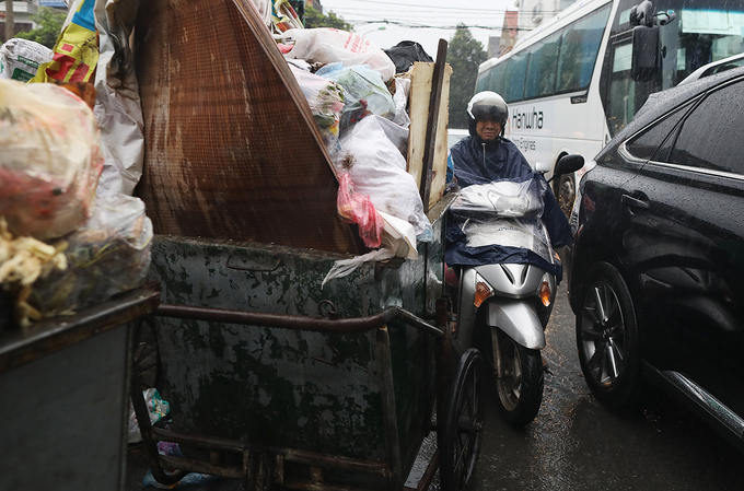 Chiều 3/7, lịch thu gom rác của nhiều đơn vị môi trường chậm hơn so với ngày thường dẫn đến tình trạng xe rác nằm ngổn ngang dưới lòng đường Trung Văn (Nam Từ Liêm), choán phần đường của các phương tiện tham gia giao thông.