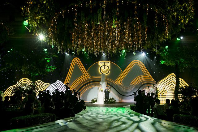 Sân khấu tiệc cưới được trang trí theo hình núi non cách điệu. Ngoài sân khấu như cổ tích thì dàn siêu xe xuất hiện trước nơi tổ chức tiệc cưới cũng gây ồn ào, tạo sự chú ý cho đông đảo khán giả và người dân.