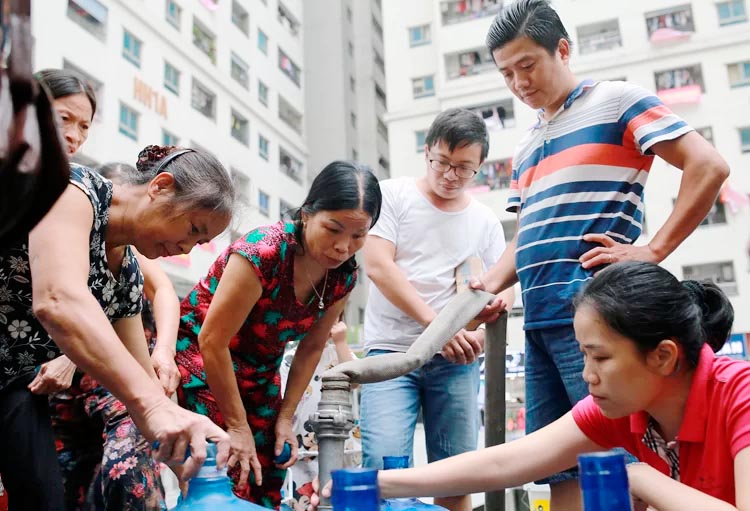 Cư dân tổ hợp chung cư HH Linh Đàm lấy nước sinh hoạt từ xe téc do những ngày qua nước sông Đà không đảm bảo chất lượng. Ảnh: Tất Định.