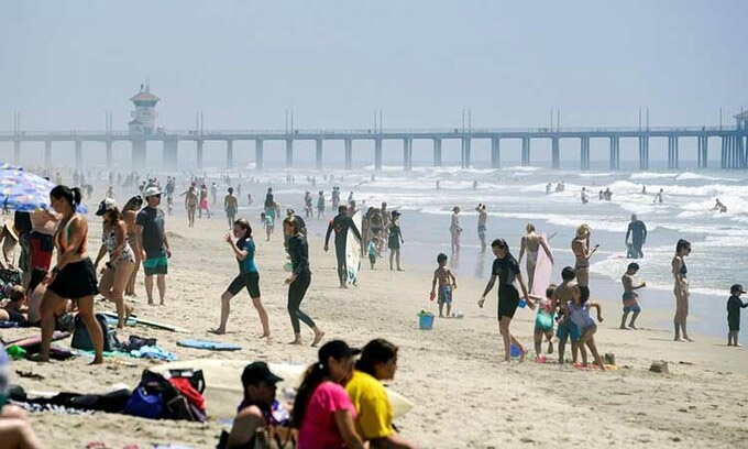 Người dân tràn ngập bãi biển tại thành phố Huntington Beach, bang California, Mỹ hôm 25/4. Ảnh: Reuters.